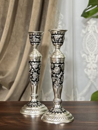 آینه و شمعدان قلمزنی گل شیرازی یکی از فاخرترین آثار صنایع دستی ایران است که جایگاه ویژه‌ای در سنت‌های عقد و عروسی دارد. این اثر نه تنها بخشی از زیبایی سفره عقد محسوب می‌شود، بلکه به عنوان هدیه‌ای ارزشمند در جهیزیه عروس نیز جایگاهی خاص دارد. استفاده از آینه و شمعدان در عروسی ریشه در فرهنگ ایرانی دارد.